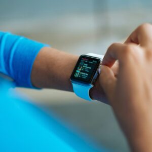 Person interacting with a smartwatch, showing a fitness application on the screen.