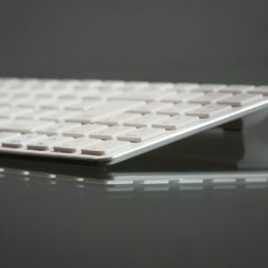 Stylish close-up of a modern slim keyboard on a reflective surface, showcasing minimalist tech design.
