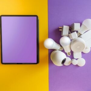 A collection of smart home devices beside a blank tablet on yellow and purple background.