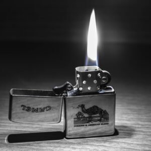 Close-up of a lit Zippo lighter with a clear flame. Perfect for themes of heat and light.