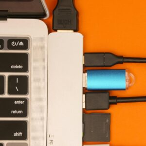 Close-up of a USB hub with multiple connections attached to a laptop, highlighting efficient cable management.